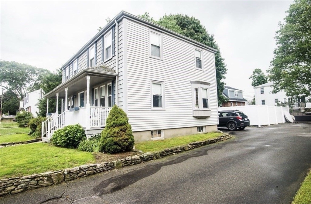 69 Keystone Street, Unit 1 Boston, MA 02132 - Photo 10 of 10 a white house that has a small yard and parking space