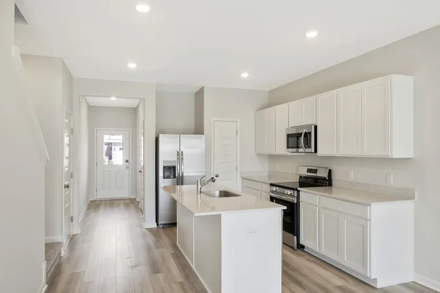 a kitchen with a sink a refrigerator and cabinets
