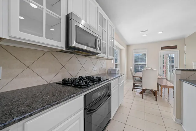 a kitchen with stainless steel appliances granite countertop a sink and a stove