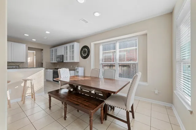 a living room with furniture and a large window with kitchen view
