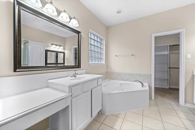 a bathroom with a sink a bathtub a mirror and vanity