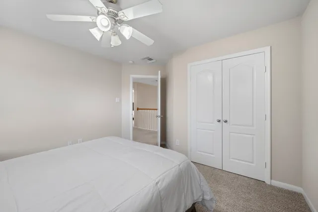 a bedroom with a bed and a chandelier fan
