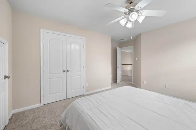 a bedroom with a bed and a chandelier fan