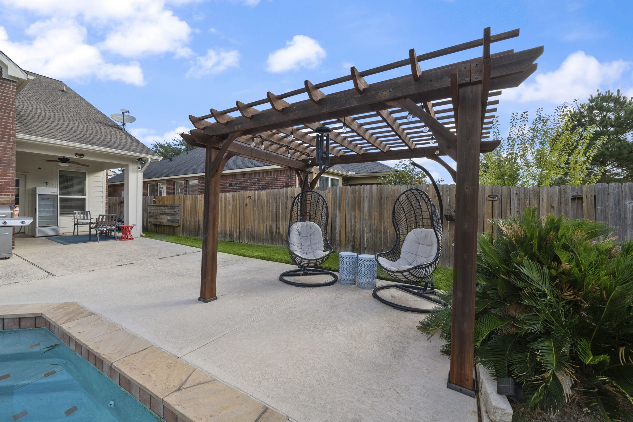 9431 Thurber Ridge Drive Spring, TX 77379 - Photo 38 of 44 Enjoy evenings by the pool under the pergola with seating provided.