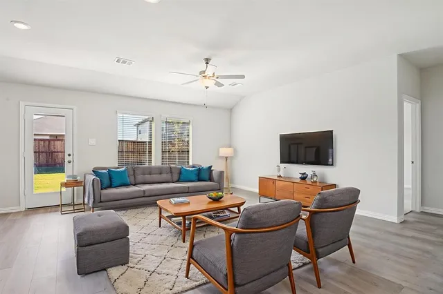 a living room with furniture a flat screen tv and a window