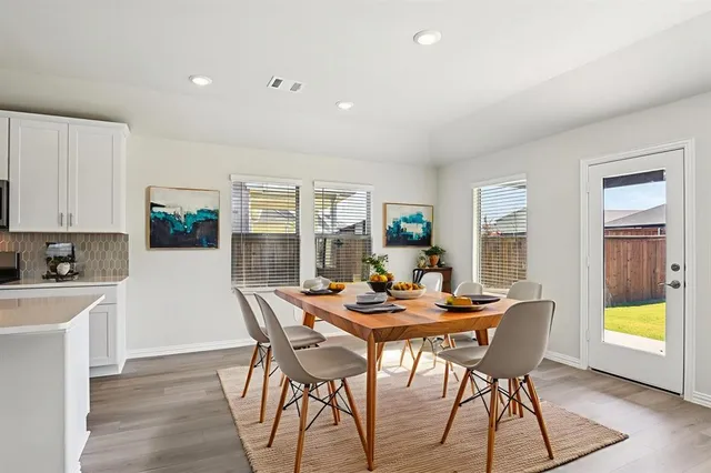 a dining room with furniture a rug and wooden floor