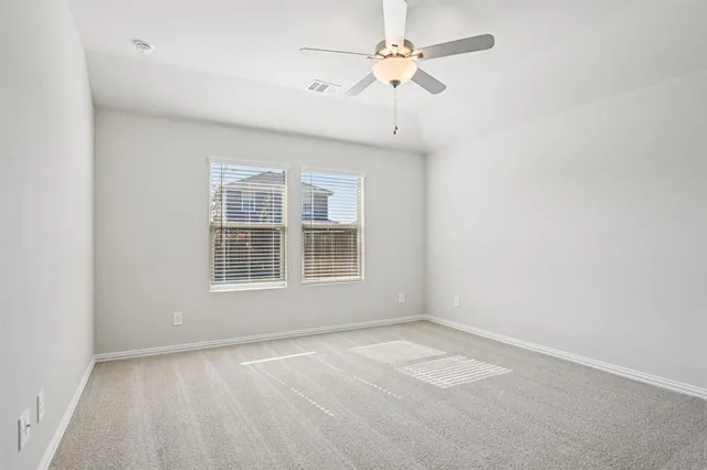 an empty room with a window and a fan