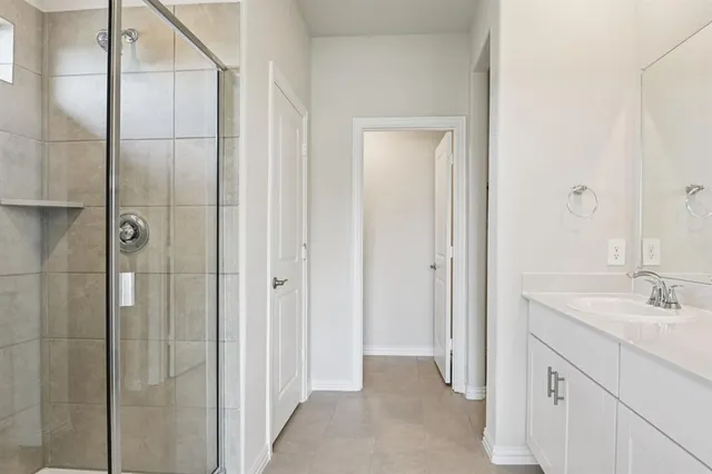 a bathroom with a double vanity sink a mirror and shower