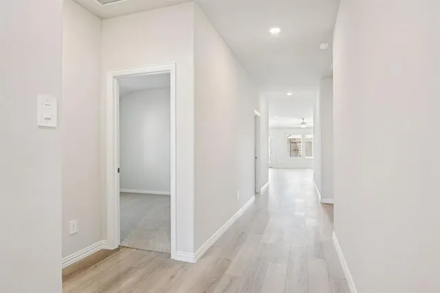 a view of a hallway with wooden floor