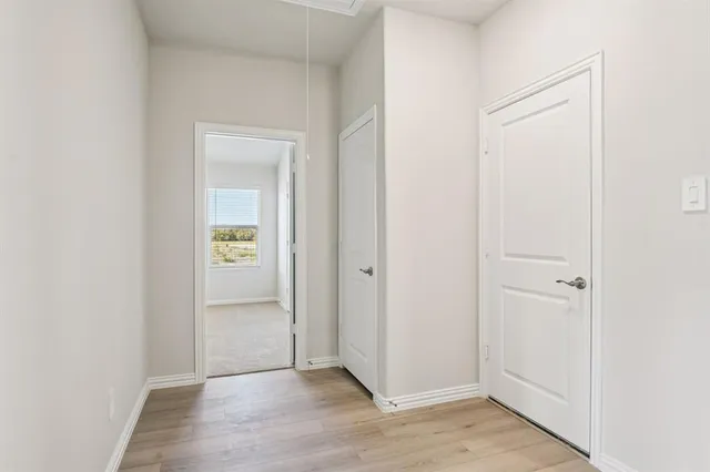 a view of an empty room with closet and a window