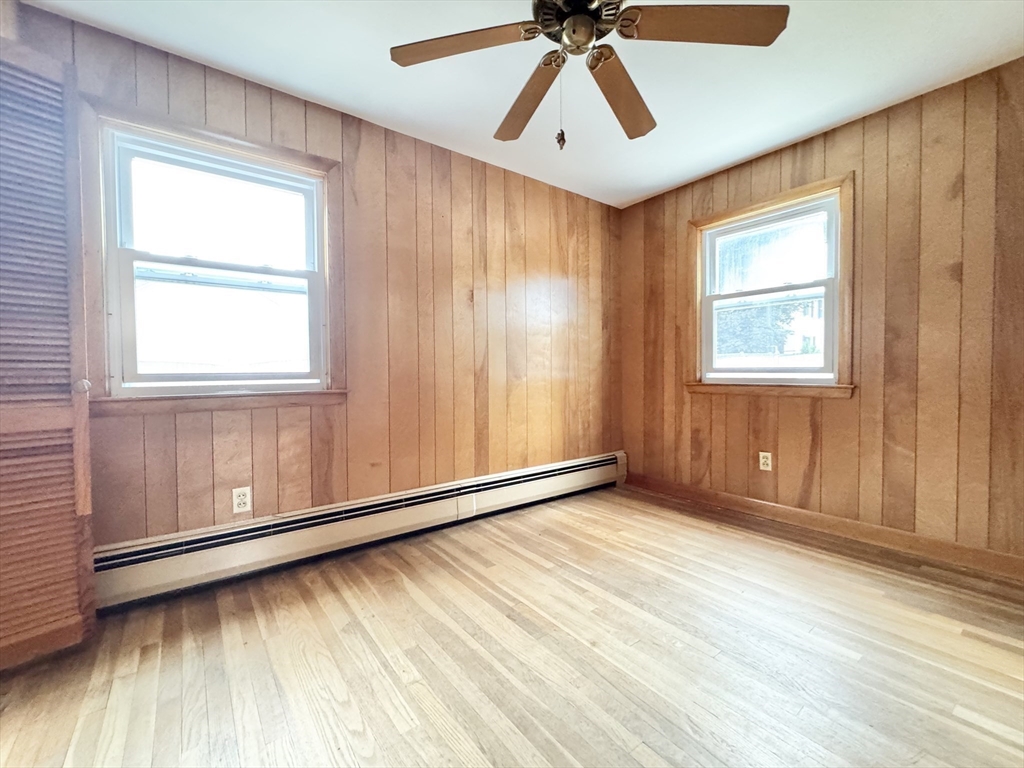 7 Roland Road Peabody, MA 01960 - Photo 12 of 24 an empty room with wooden floor fan and windows
