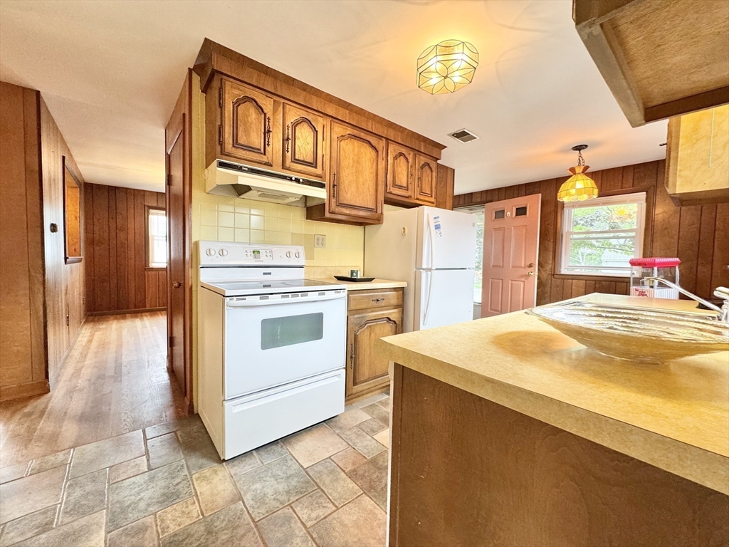 7 Roland Road Peabody, MA 01960 - Photo 3 of 24 a kitchen with stainless steel appliances granite countertop a sink and cabinets
