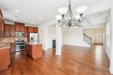a kitchen with a refrigerator a sink and wooden floor