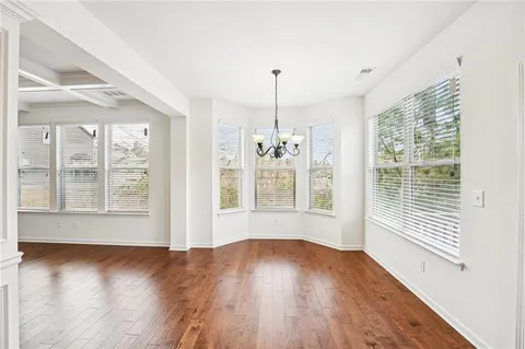 a large kitchen with stainless steel appliances granite countertop a lot of counter space and wooden floors