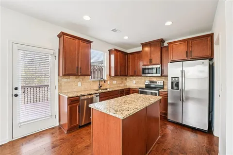 a kitchen with stainless steel appliances granite countertop a stove top oven a sink and dishwasher