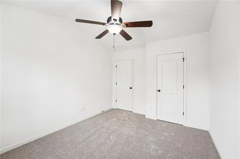 a view of a hallway with a ceiling fan
