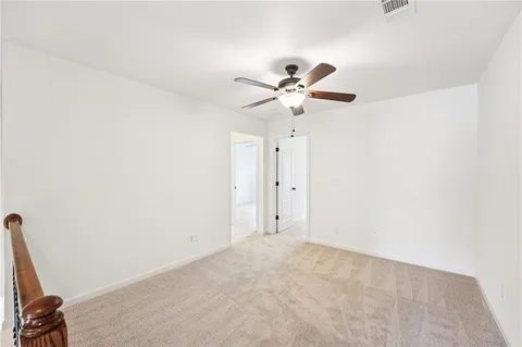 an empty room with a window and a ceiling fan