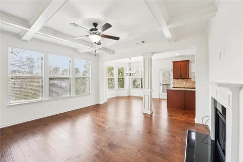 a kitchen with stainless steel appliances granite countertop a refrigerator a sink dishwasher a oven and a dining table with wooden floor