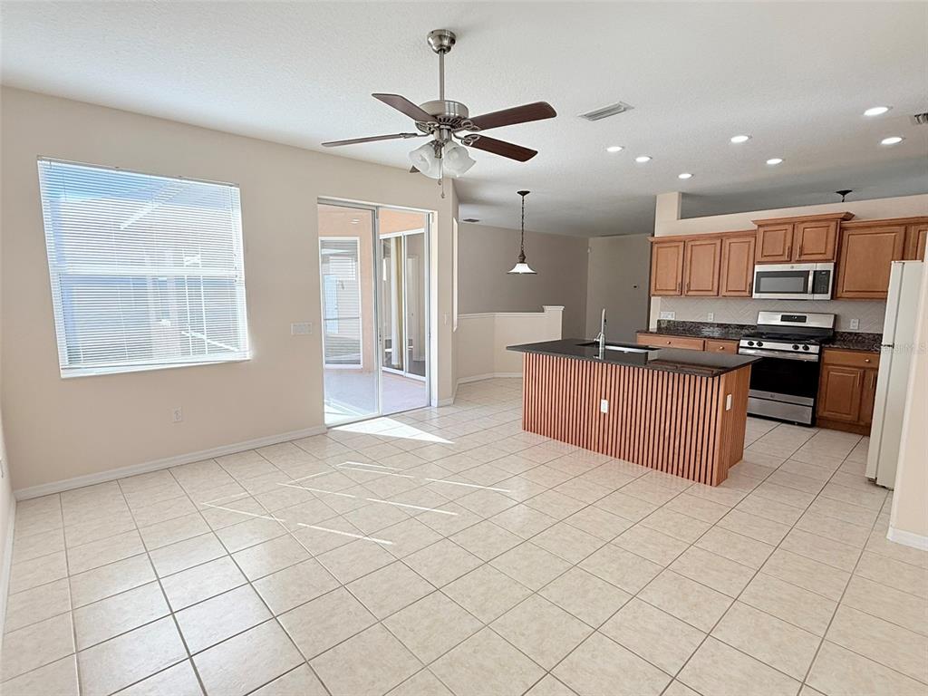 14163 Cattle Egret PIace Lakewood Ranch, FL 34202 - Photo 11 of 50 a kitchen with stainless steel appliances granite countertop a stove top oven a sink a counter space and cabinets