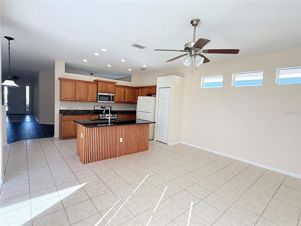 14163 Cattle Egret PIace Lakewood Ranch, FL 34202 - Photo 13 of 50 a kitchen with stainless steel appliances a refrigerator and microwave
