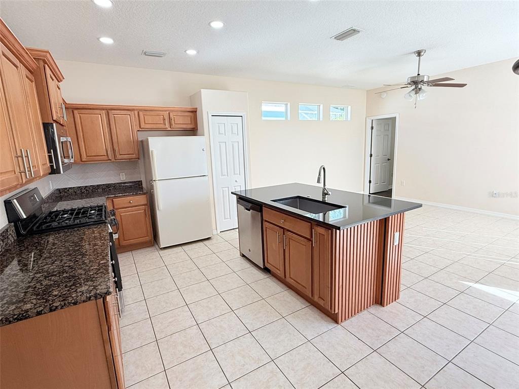14163 Cattle Egret PIace Lakewood Ranch, FL 34202 - Photo 15 of 50 a kitchen with granite countertop a sink stove and refrigerator