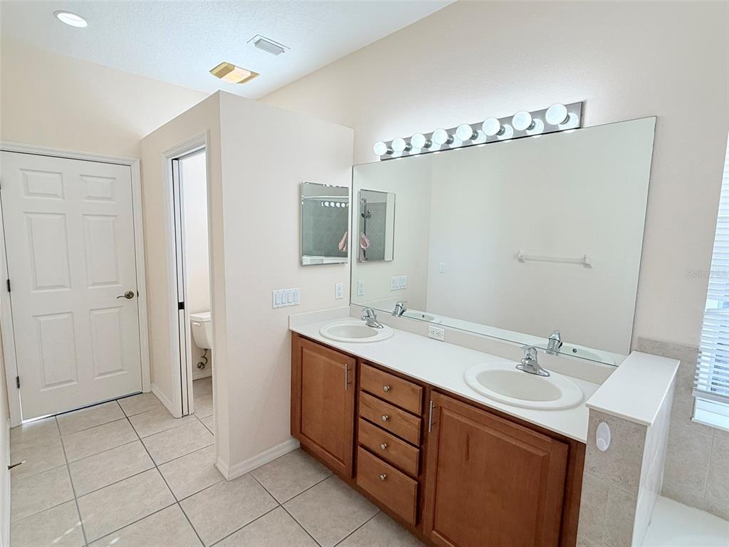 14163 Cattle Egret PIace Lakewood Ranch, FL 34202 - Photo 21 of 50 a spacious bathroom with a double vanity sink a mirror and a shower