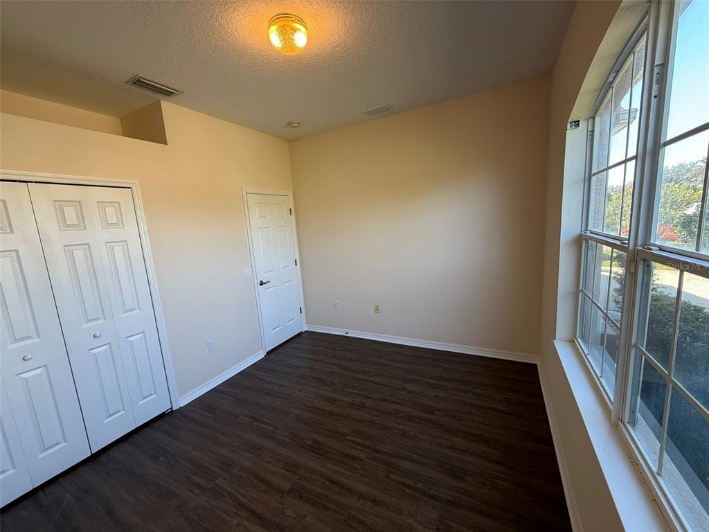 14163 Cattle Egret PIace Lakewood Ranch, FL 34202 - Photo 25 of 50 a view of an empty room with wooden floor and a window