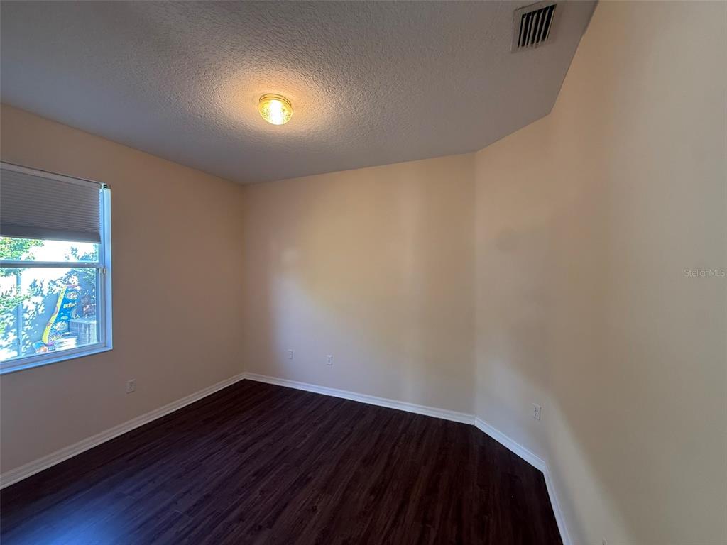 14163 Cattle Egret PIace Lakewood Ranch, FL 34202 - Photo 26 of 50 a view of an empty room with wooden floor and a window