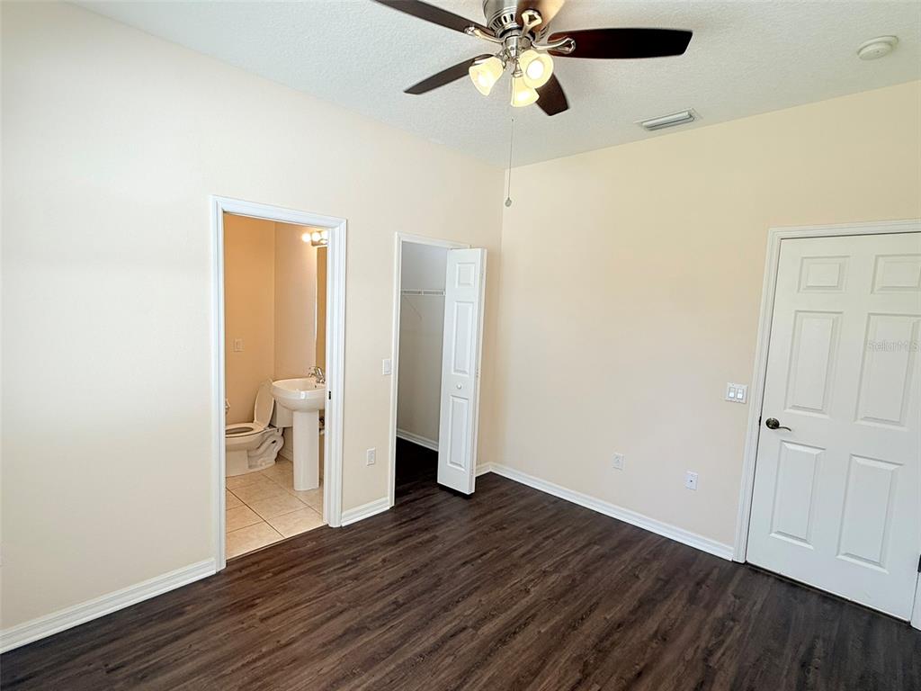 14163 Cattle Egret PIace Lakewood Ranch, FL 34202 - Photo 29 of 50 an empty room with wooden floor and a ceiling fan
