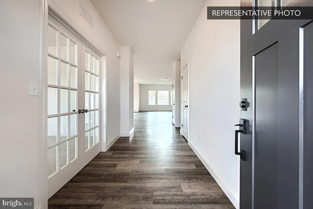 a view of a hallway with wooden floor and windows