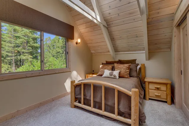 a bedroom with a bed next to a large window