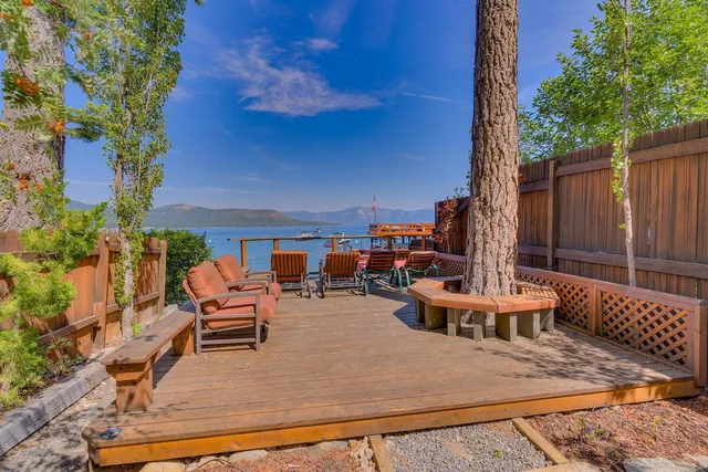 a view of a patio with table and chairs potted plants and a large tree