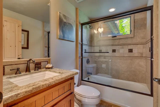 a bathroom with a granite countertop sink toilet and shower