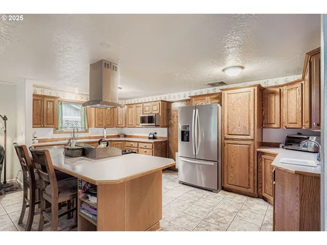a kitchen with refrigerator and chairs