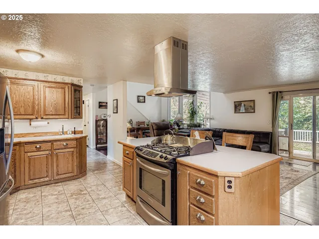 a kitchen with stainless steel appliances granite countertop a stove a sink dishwasher and a refrigerator