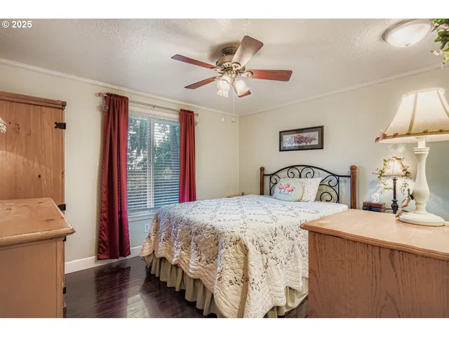 a bedroom with a bed a dresser and a chandelier