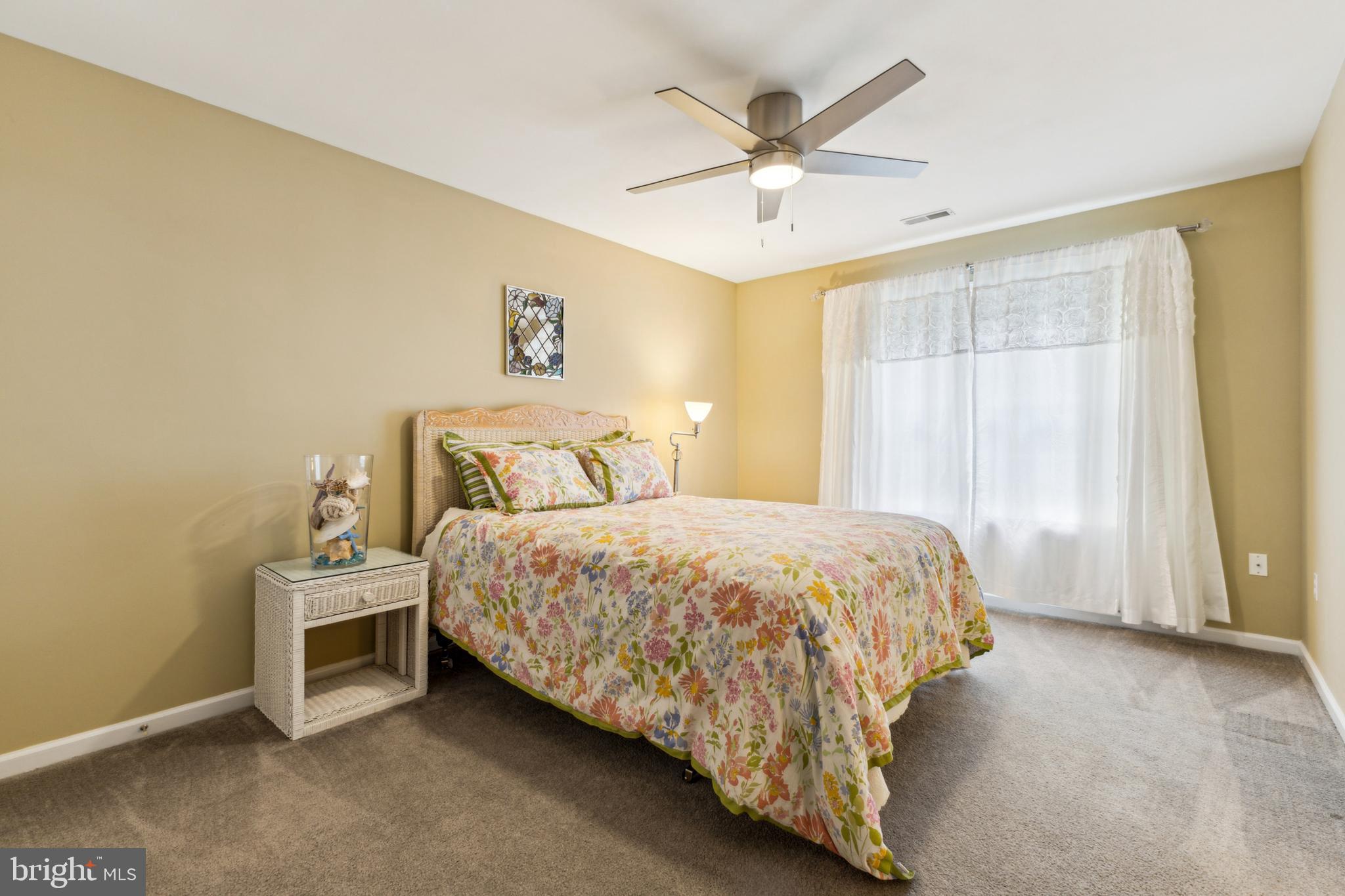 633 Ruxton Road, Unit 75 Solomons, MD 20629 - Photo 34 of 43 a bedroom with a bed and a ceiling fan