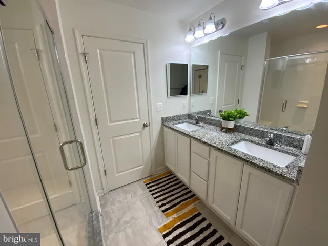 a bathroom with double vanity and a mirror