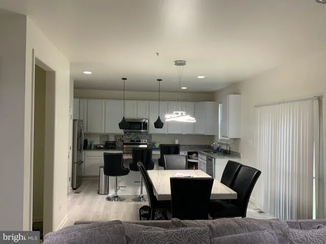 a view of a dining room with furniture a kitchen and chandelier