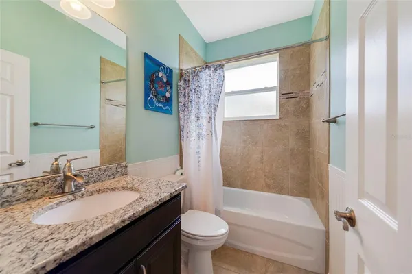 a bathroom with a granite countertop sink toilet and shower