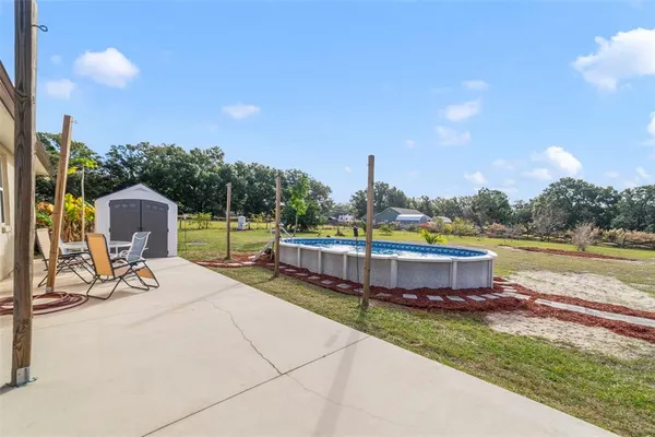 a view of a swimming pool with a yard and sitting area