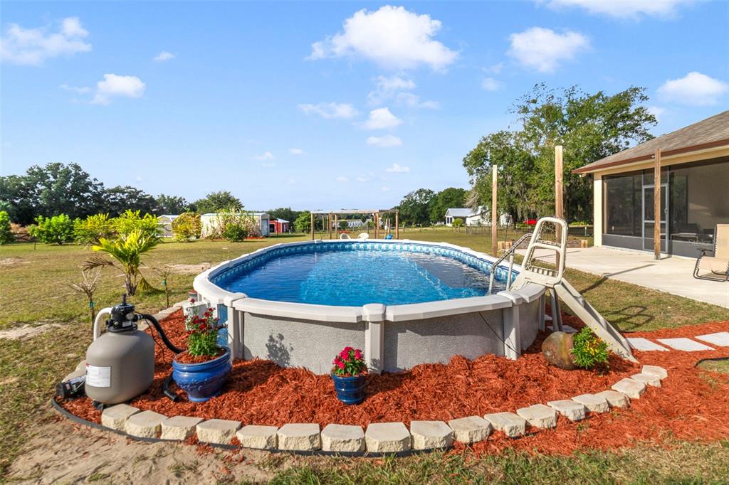 37041 North Thrill Hill Road Eustis, FL 32736 - Photo 21 of 25 a view of a swimming pool with a patio and a yard