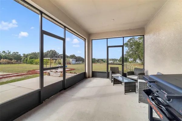 a living room with furniture and a floor to ceiling window