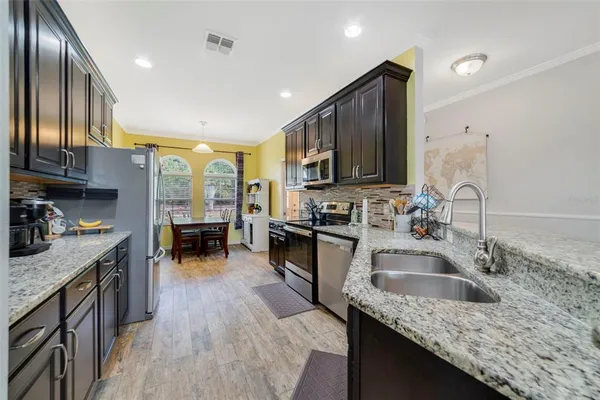 a kitchen with stainless steel appliances granite countertop a sink stove and refrigerator