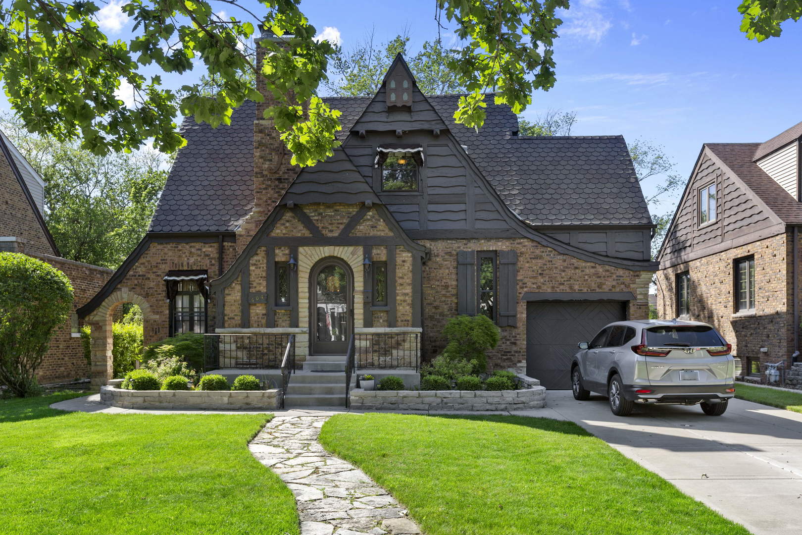404 Selborne Road Riverside, IL 60546 - Photo 1 of 26 a front view of a house with a garden and plants