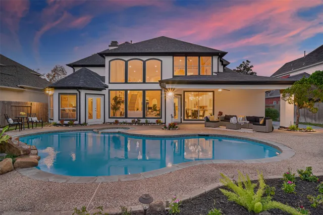a view of a house with pool and chairs