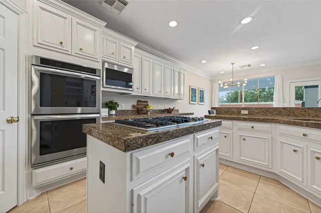 a kitchen with a dining table chairs and white cabinets