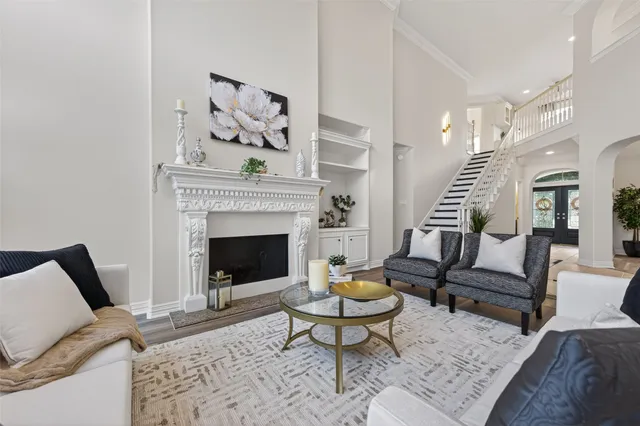 a living room with furniture fireplace and a large window