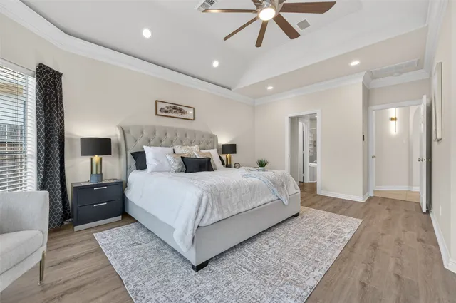a bedroom with a large bed and a chandelier