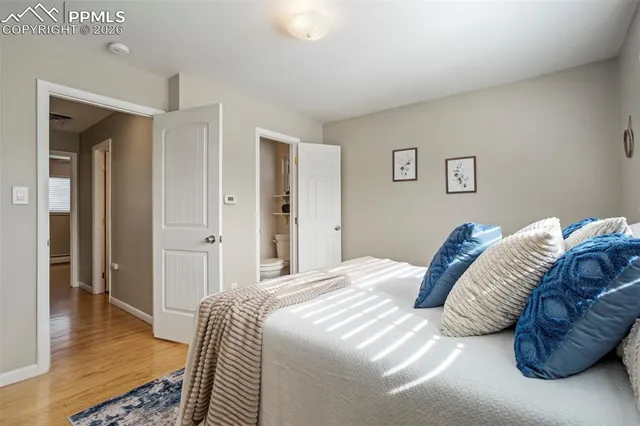 a bedroom with a bed and a wooden floor